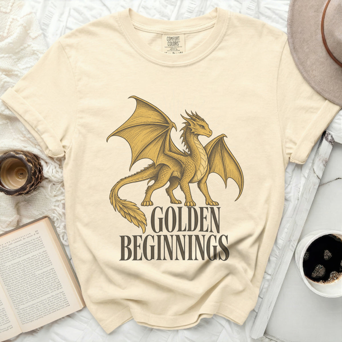 Cream t-shirt with a golden dragon graphic and text "GOLDEN BEGINNINGS".