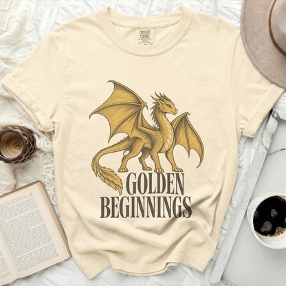 Cream t-shirt with a golden dragon graphic and text "GOLDEN BEGINNINGS".