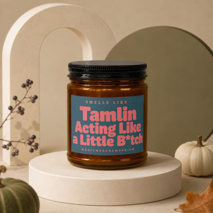 Amber jar candle with blue label reading "Smells Like Tamlin Acting Like a Little B*tch."