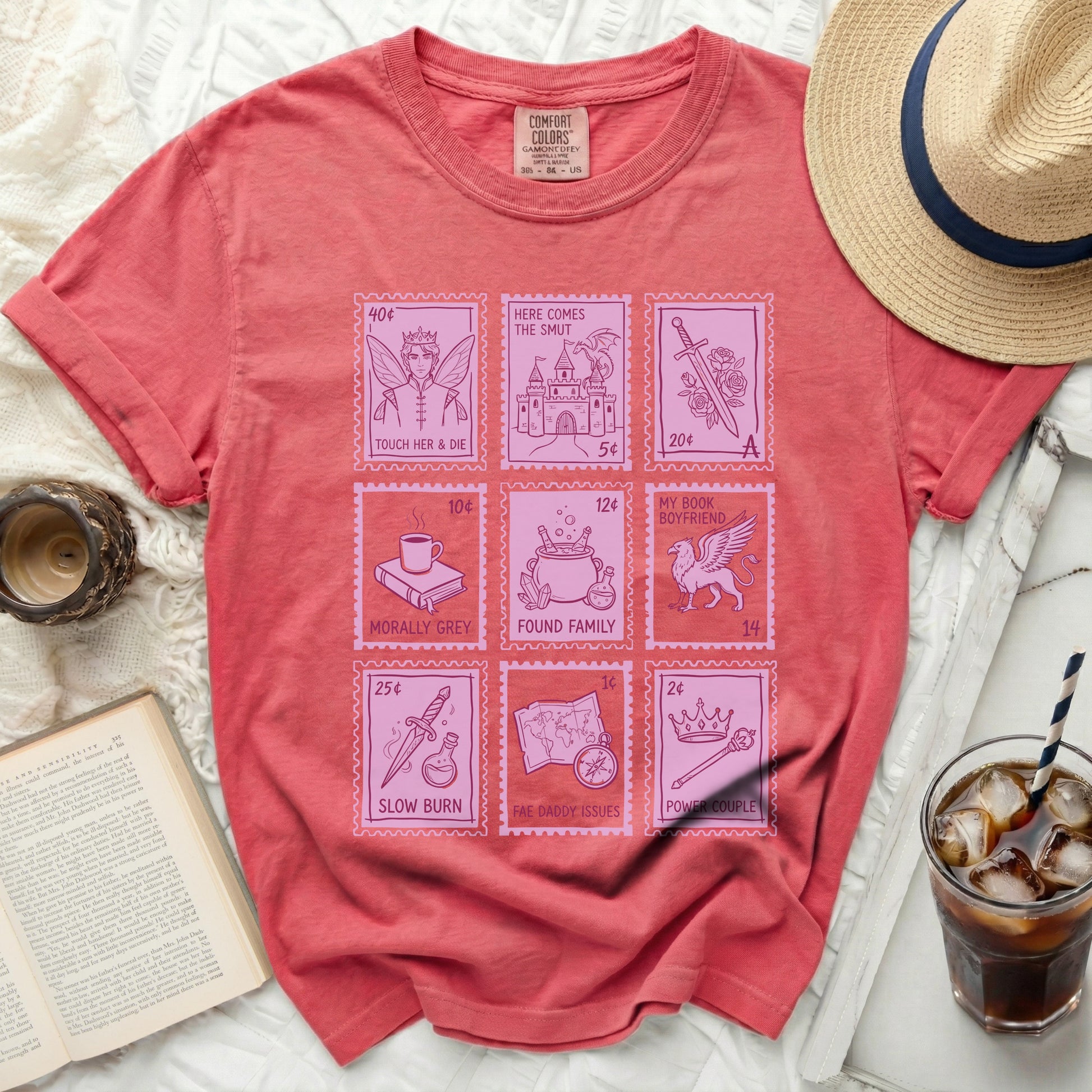 Coral t-shirt with pink postage stamp graphics featuring romance book tropes.