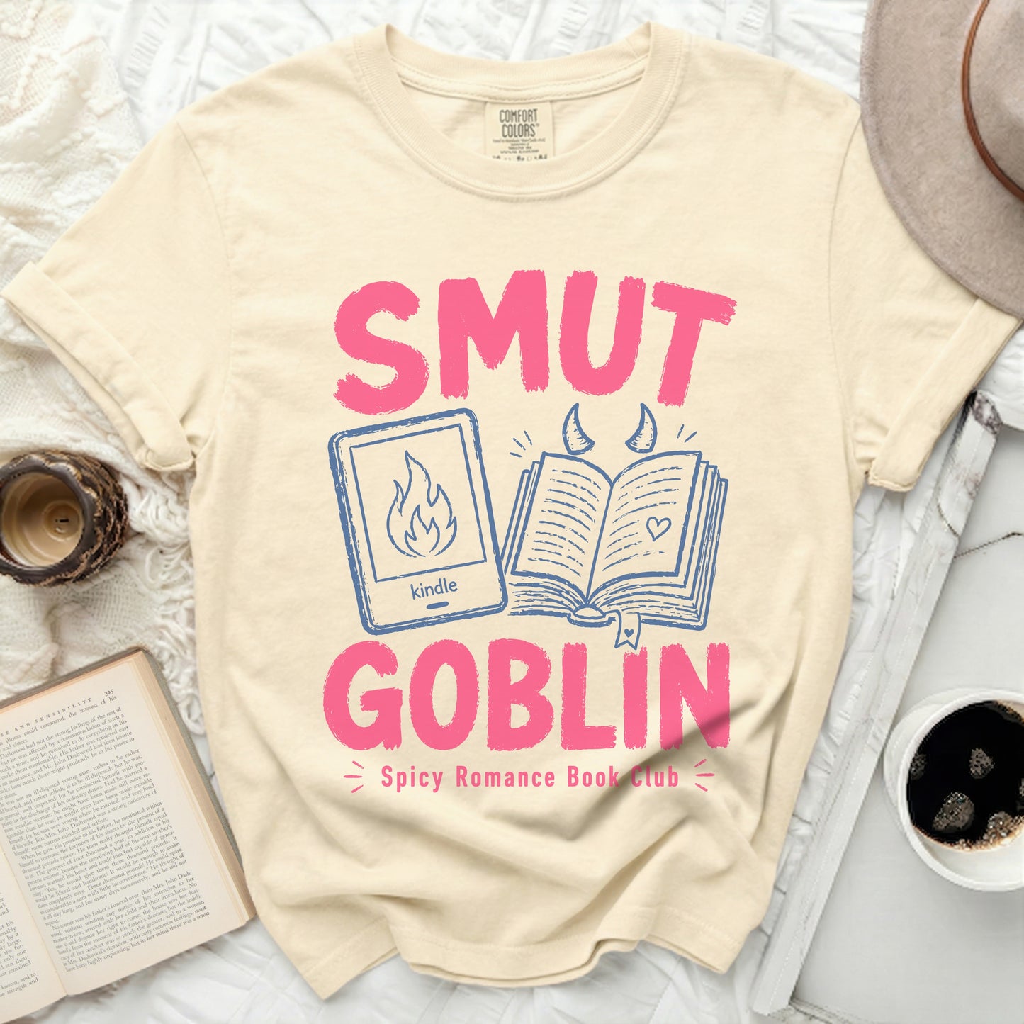 "Smut Goblin" text with kindle and book graphics on cream t-shirt.