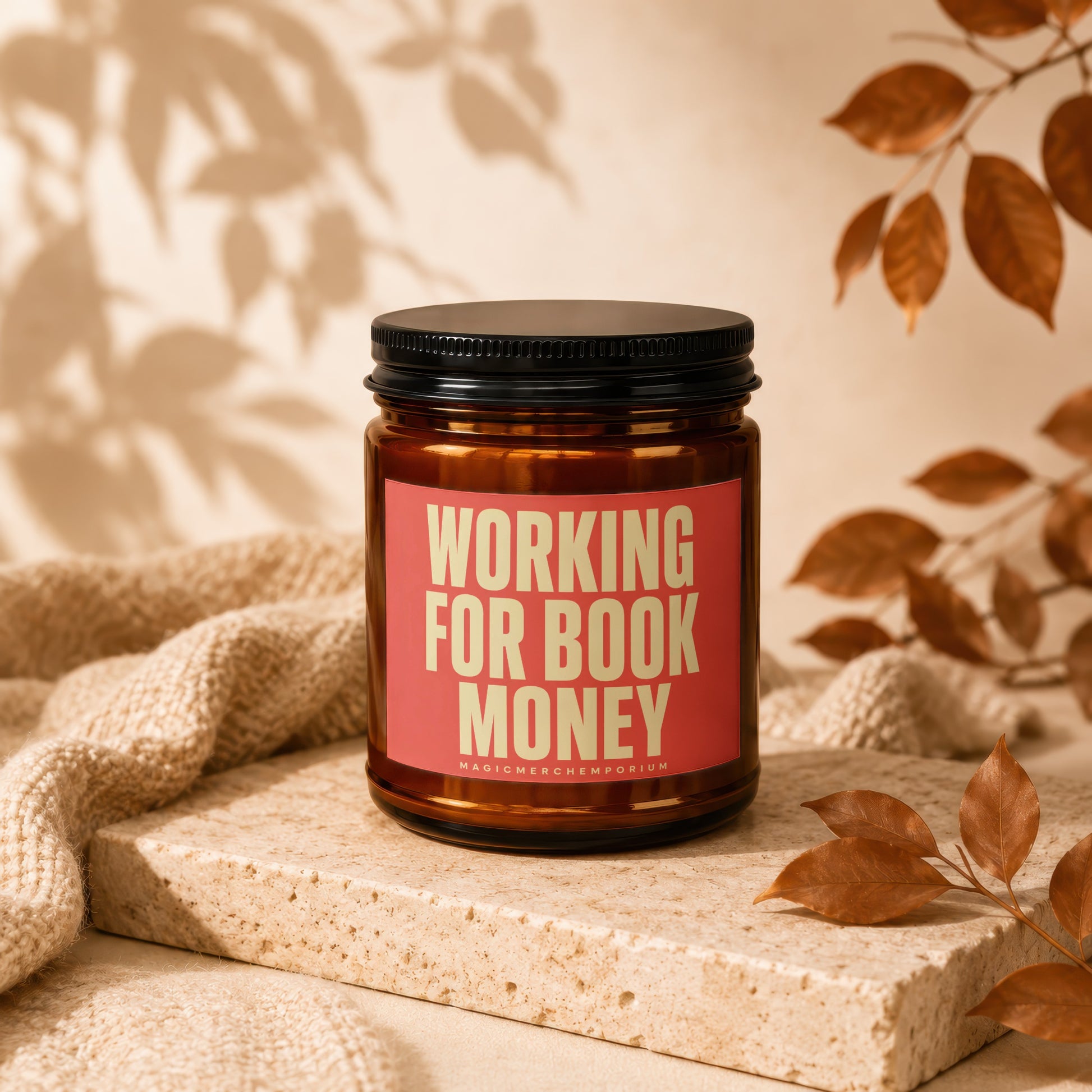 Amber jar candle with red label reading "Working For Book Money".