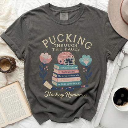 Dark t-shirt with "Pucking Through The Pages" and hockey romance themes.