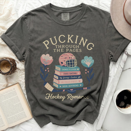 Dark t-shirt with "Pucking Through The Pages" and hockey romance themes.