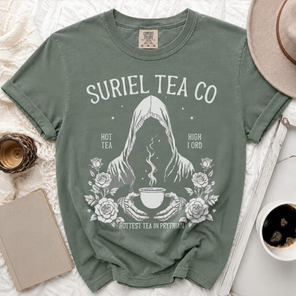 Green t-shirt with Suriel Tea Co. logo featuring a hooded figure holding a steaming teacup.