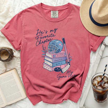 Coral t-shirt with "He's my Favorite Chapter" and books, hockey gear.