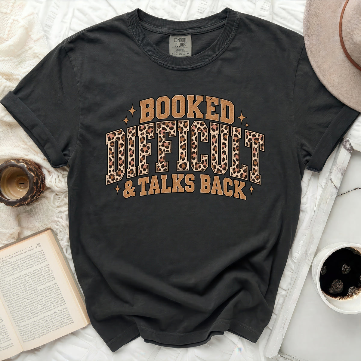Black t-shirt with "Booked Difficult & Talks Back" graphic featuring leopard print.