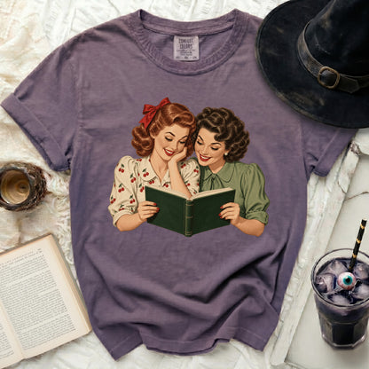 Lavender t-shirt with vintage illustration of two women reading a book.