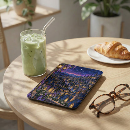Tablet with stained glass city design next to iced matcha and croissant.