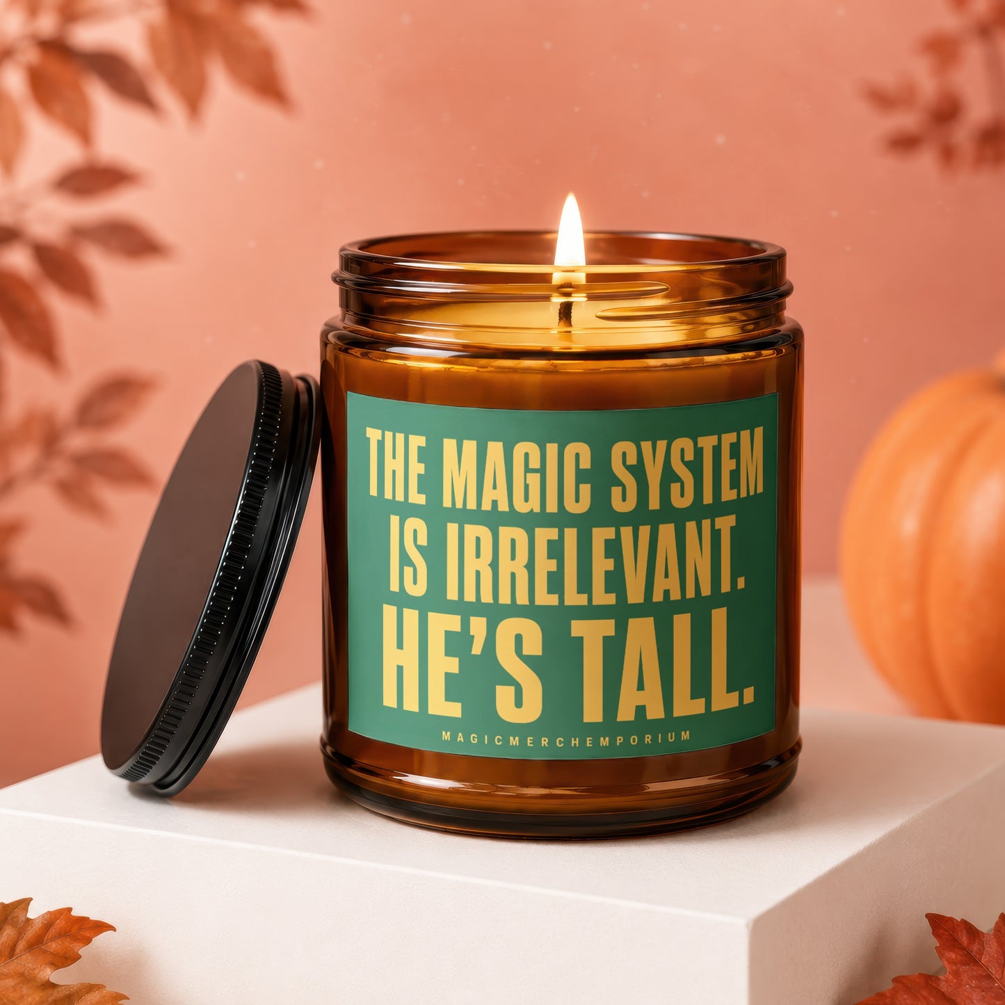 Amber glass candle with green label text: THE MAGIC SYSTEM IS IRRELEVANT. HE'S TALL.