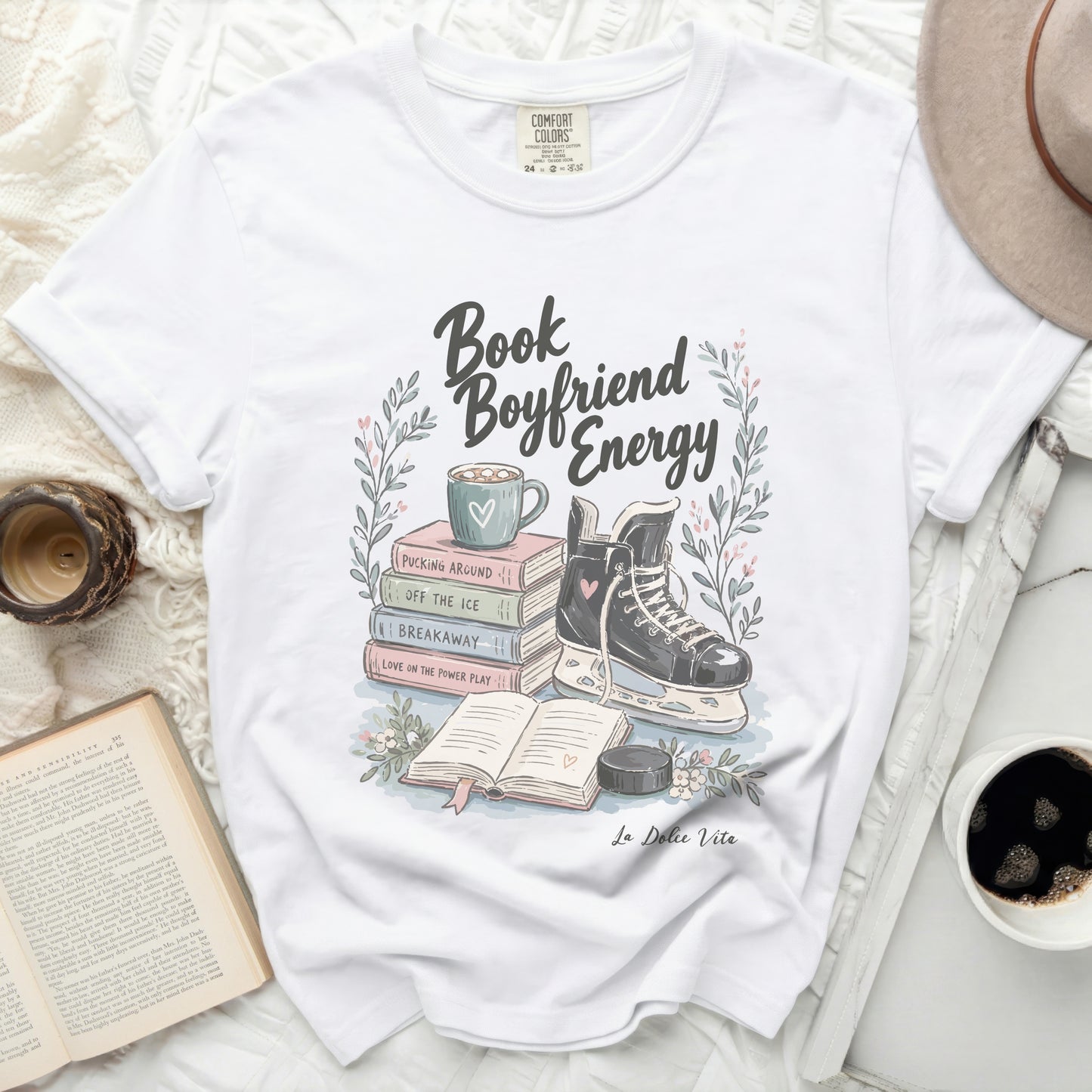 White t-shirt with "Book Boyfriend Energy" text, ice skates, and books.