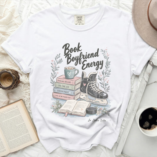 White t-shirt with "Book Boyfriend Energy" text, ice skates, and books.