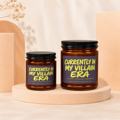 Two candles with "Currently in my villain era" text on a light-colored background.
