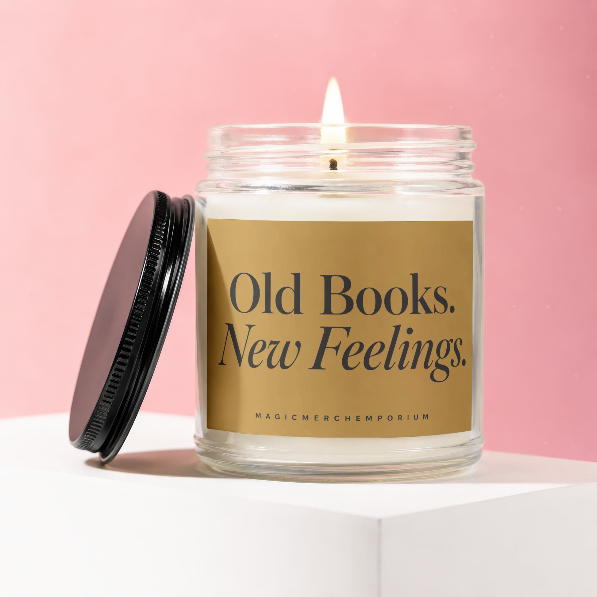 Candle with lit wick, the label reads "Old Books. New Feelings."