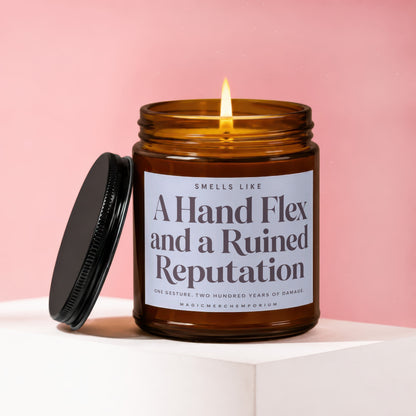 Amber jar candle with lit wick, reads "A Hand Flex and a Ruined Reputation."