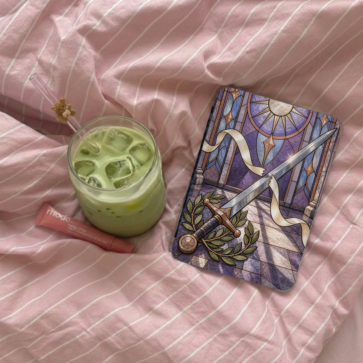 Glass of matcha latte and Rhode lip balm next to a tarot card.