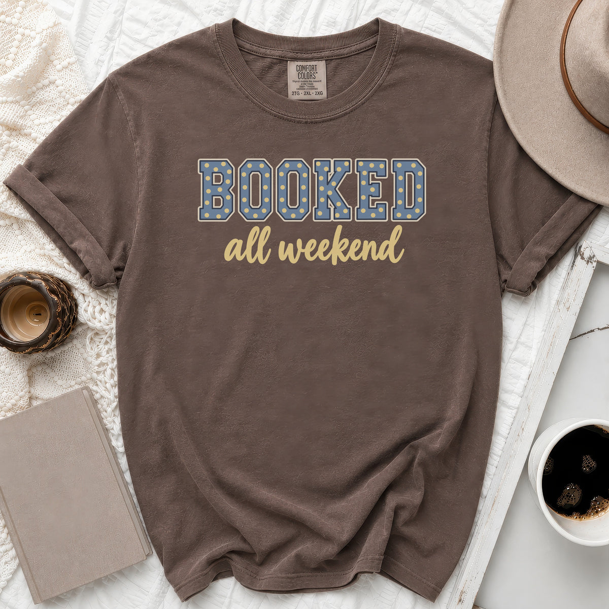 Brown t-shirt with "BOOKED all weekend" text in blue and yellow.