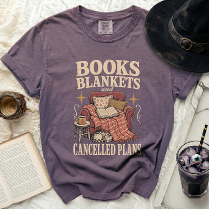 Purple t-shirt with graphic "BOOKS BLANKETS and CANCELLED PLANS".