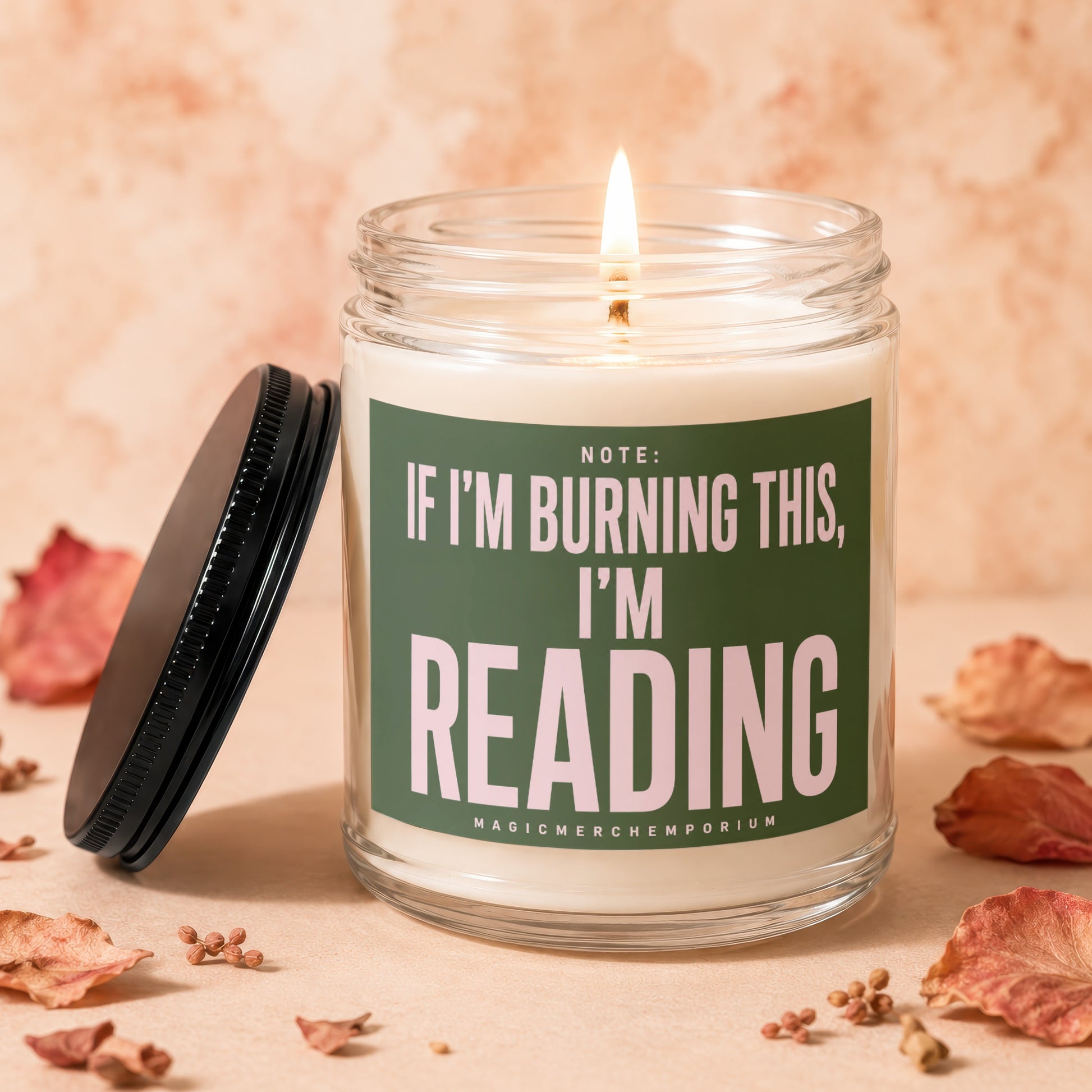 Glass candle with lit wick and label reading "Note: If I'm burning this, I'm reading."