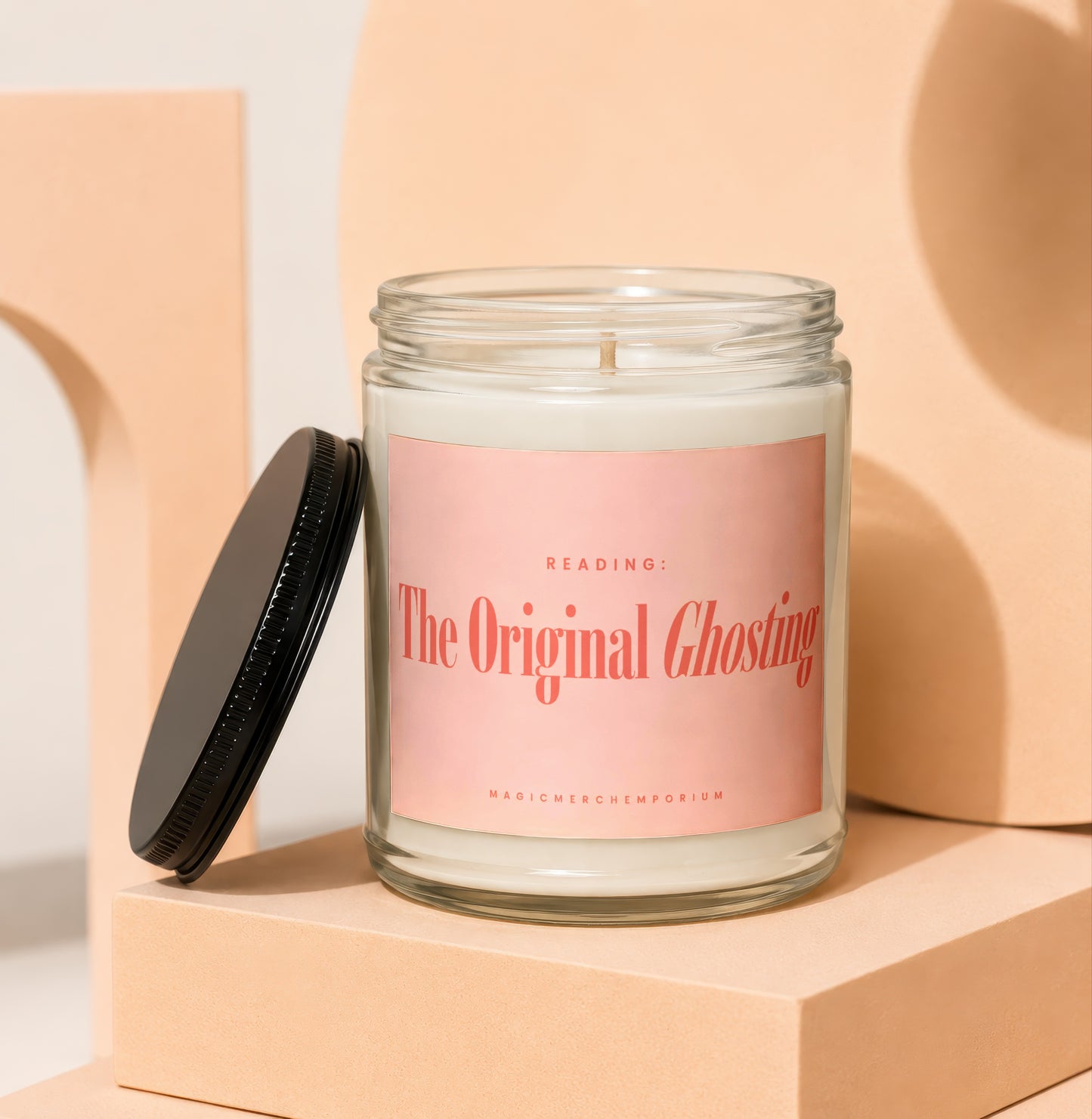 Glass jar candle with pink label reading "The Original Ghosting."