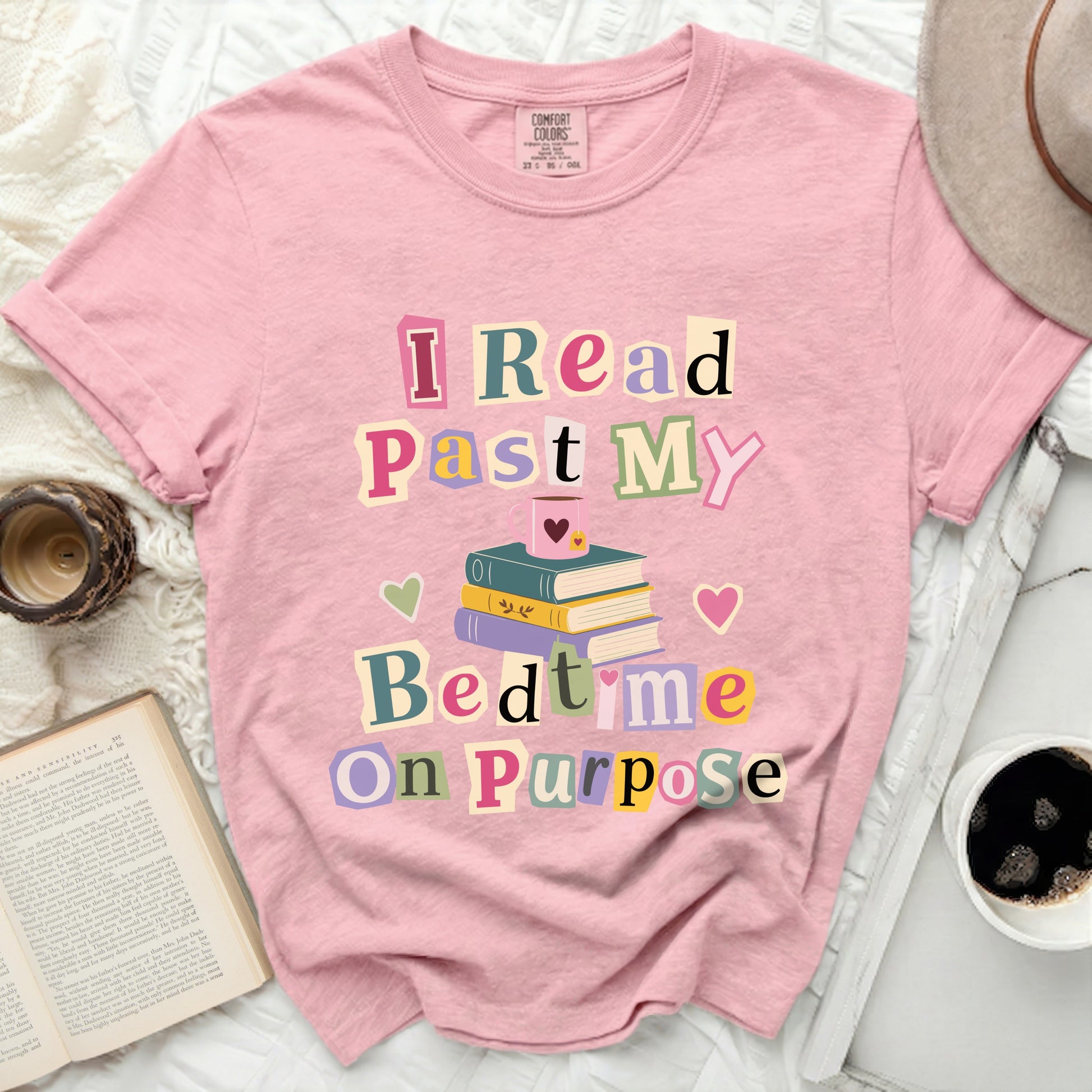 Pink t-shirt with "I Read Past My Bedtime On Purpose" text and stack of books.