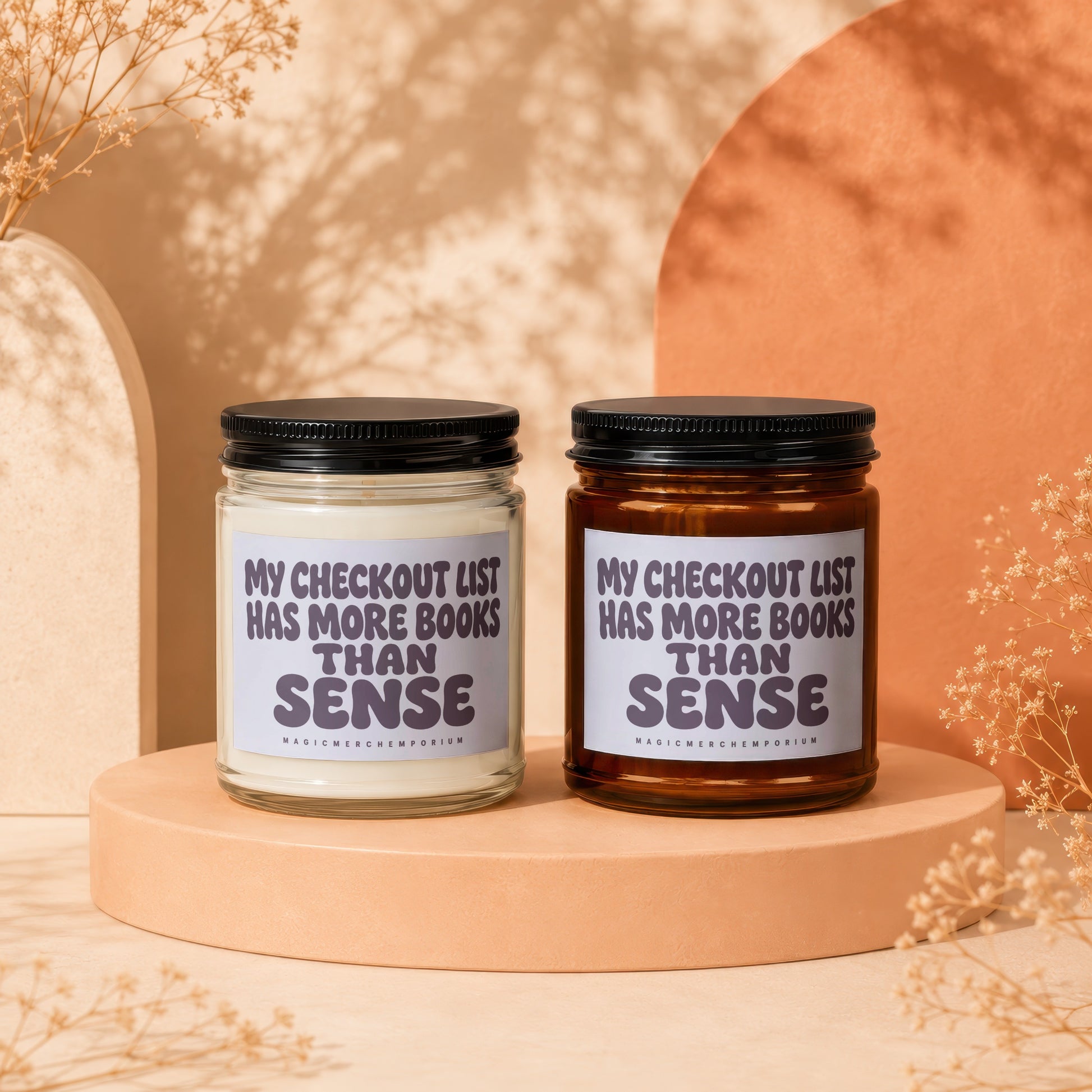 Two candles with text "My checkout list has more books than sense."