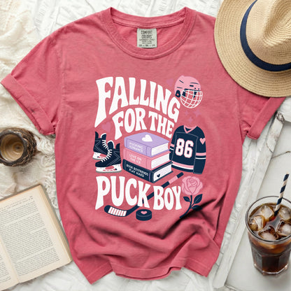 "Falling for the Puck Boy" graphic t-shirt with hockey and book illustrations.