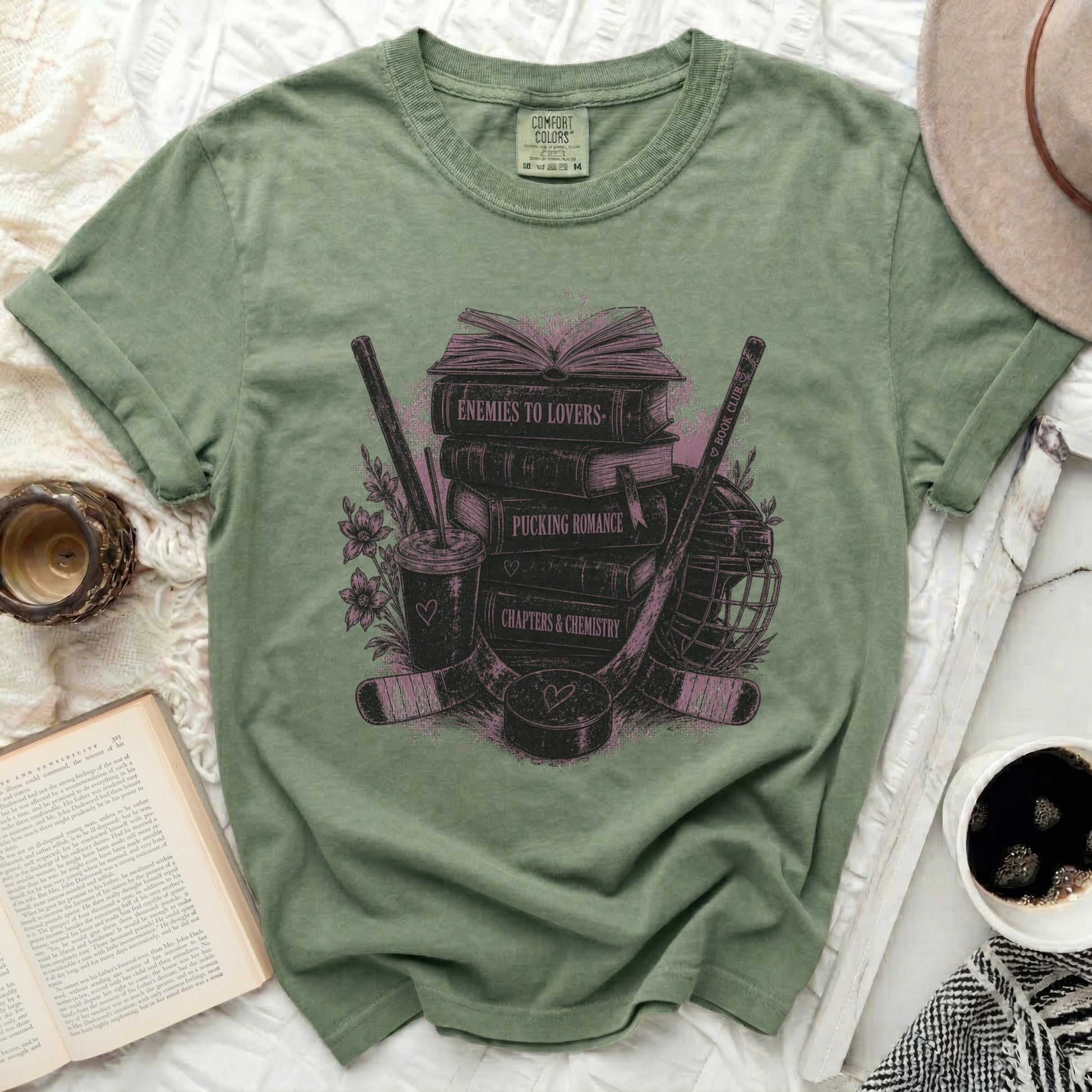 Green t-shirt with "Enemies to Lovers" and book-themed graphics.