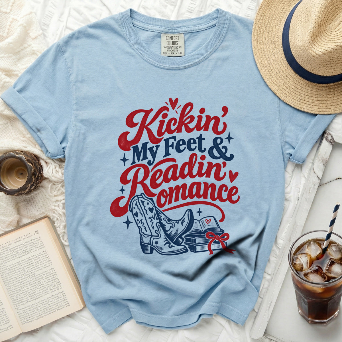 Light blue t-shirt with "Kickin' My Feet & Readin' Romance" graphic and cowboy boots.