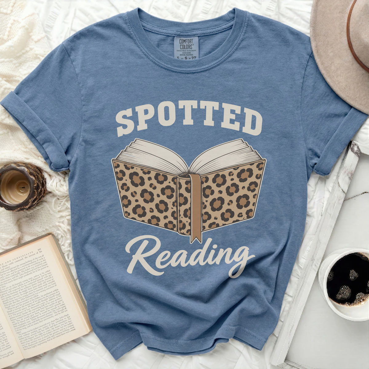 Blue t-shirt with leopard print open book graphic and "Spotted Reading" text.