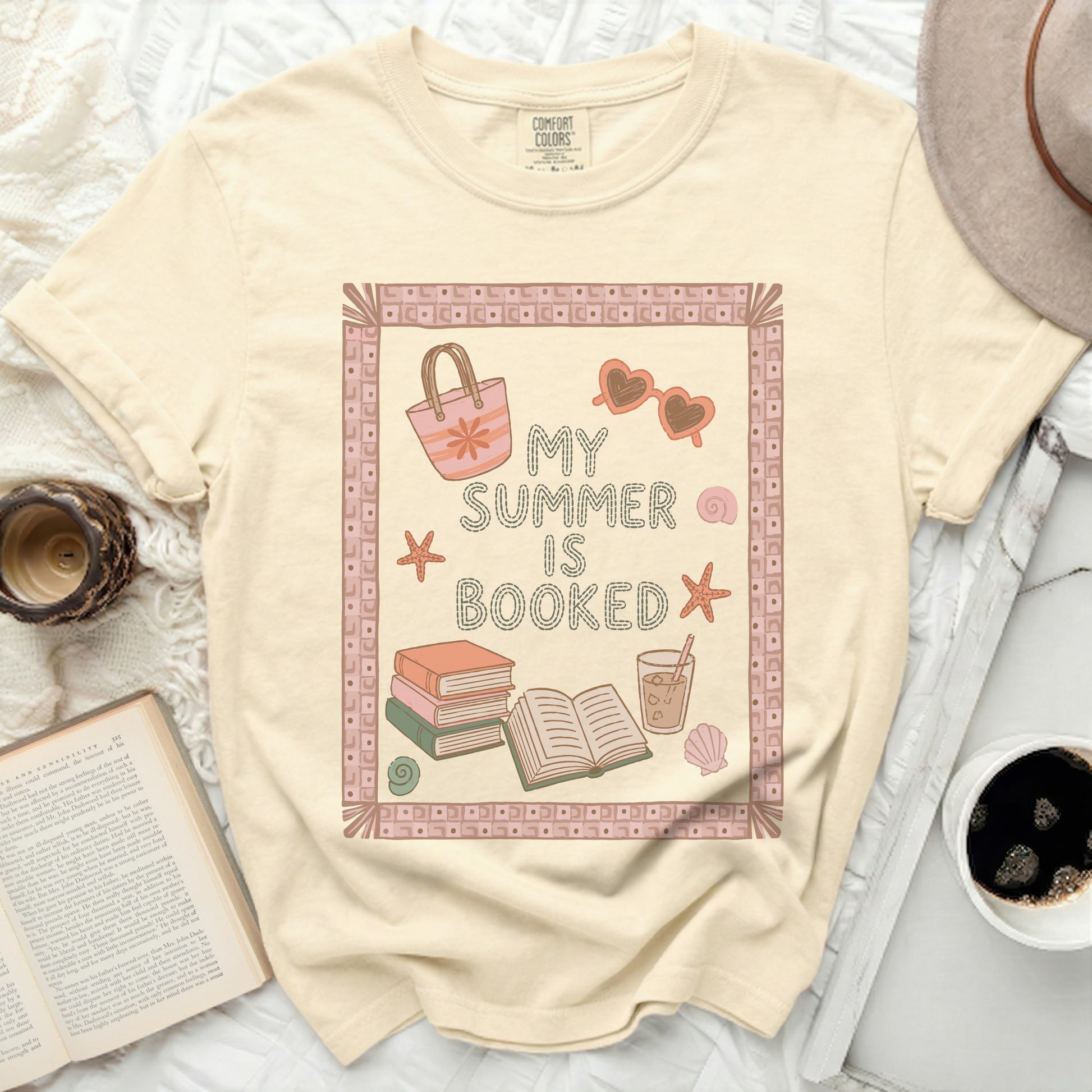 T-shirt with "My Summer is Booked" text, sunglasses, and beach bag.