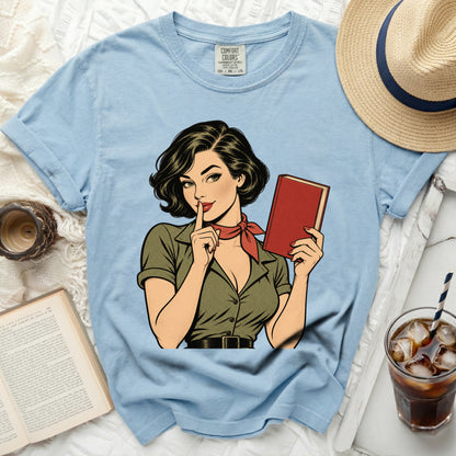Light blue t-shirt featuring a retro comic book illustration of a woman holding a book.