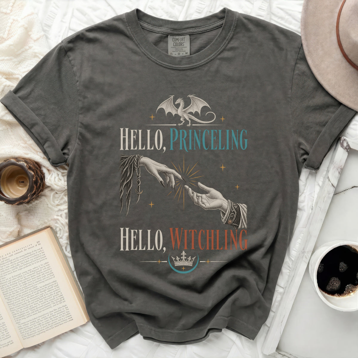 Graphic tee with dragon, hands, and text "Hello, Princeling" and "Hello, Witchling".