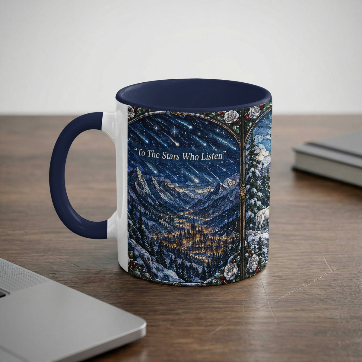 A white and dark blue ceramic mug featuring a fantasy landscape with mountains, a starry sky, and text reading To The Stars Who Listen.
