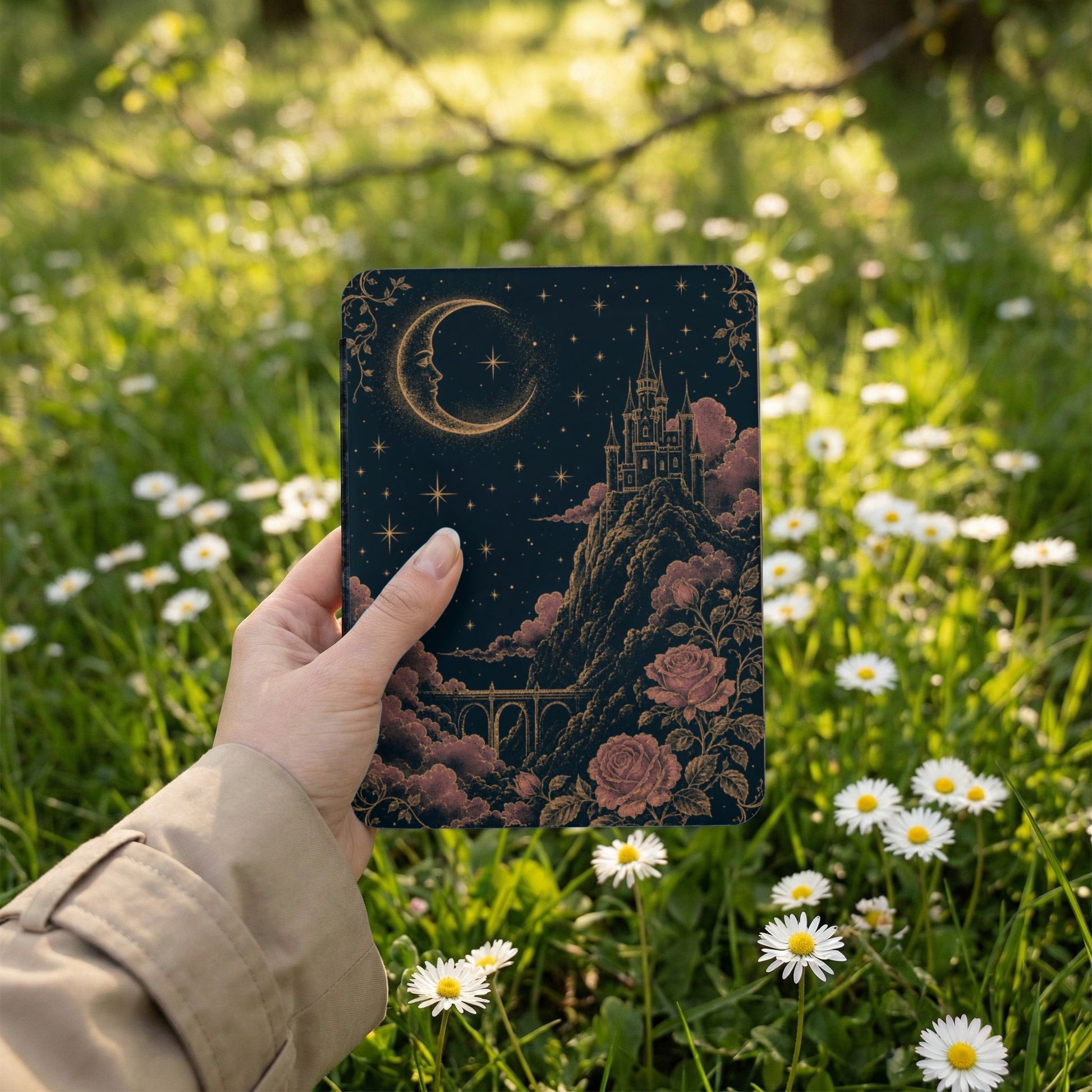 Dark cover with crescent moon, castle, roses, and starry night sky held among daisies.