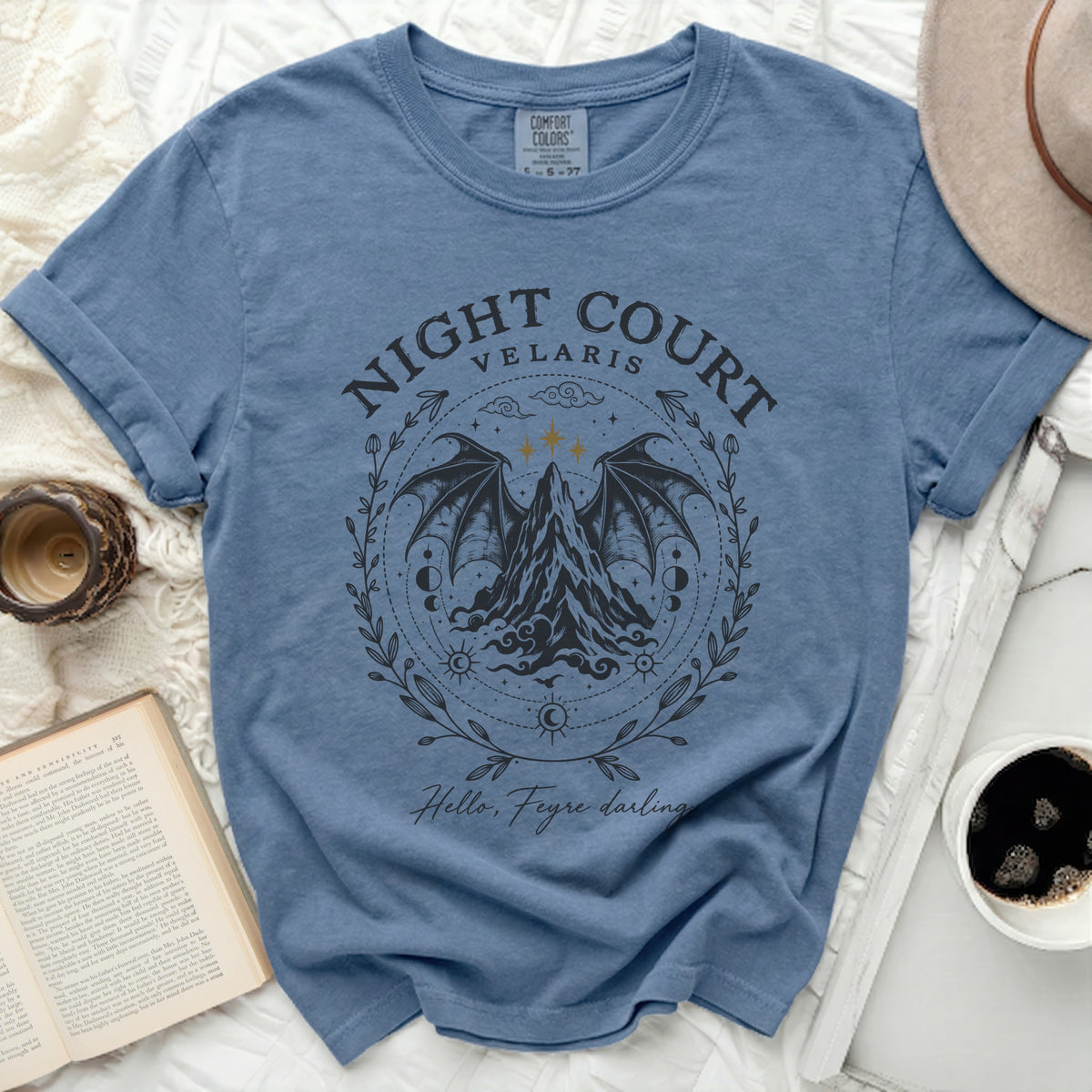A blue crewneck t-shirt with a Night Court Velaris graphic featuring winged mountains and text.