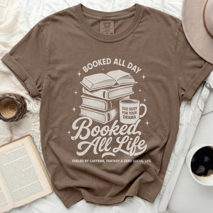Brown t-shirt with stacked books, mug, and text "Booked All Day" "Booked All Life".