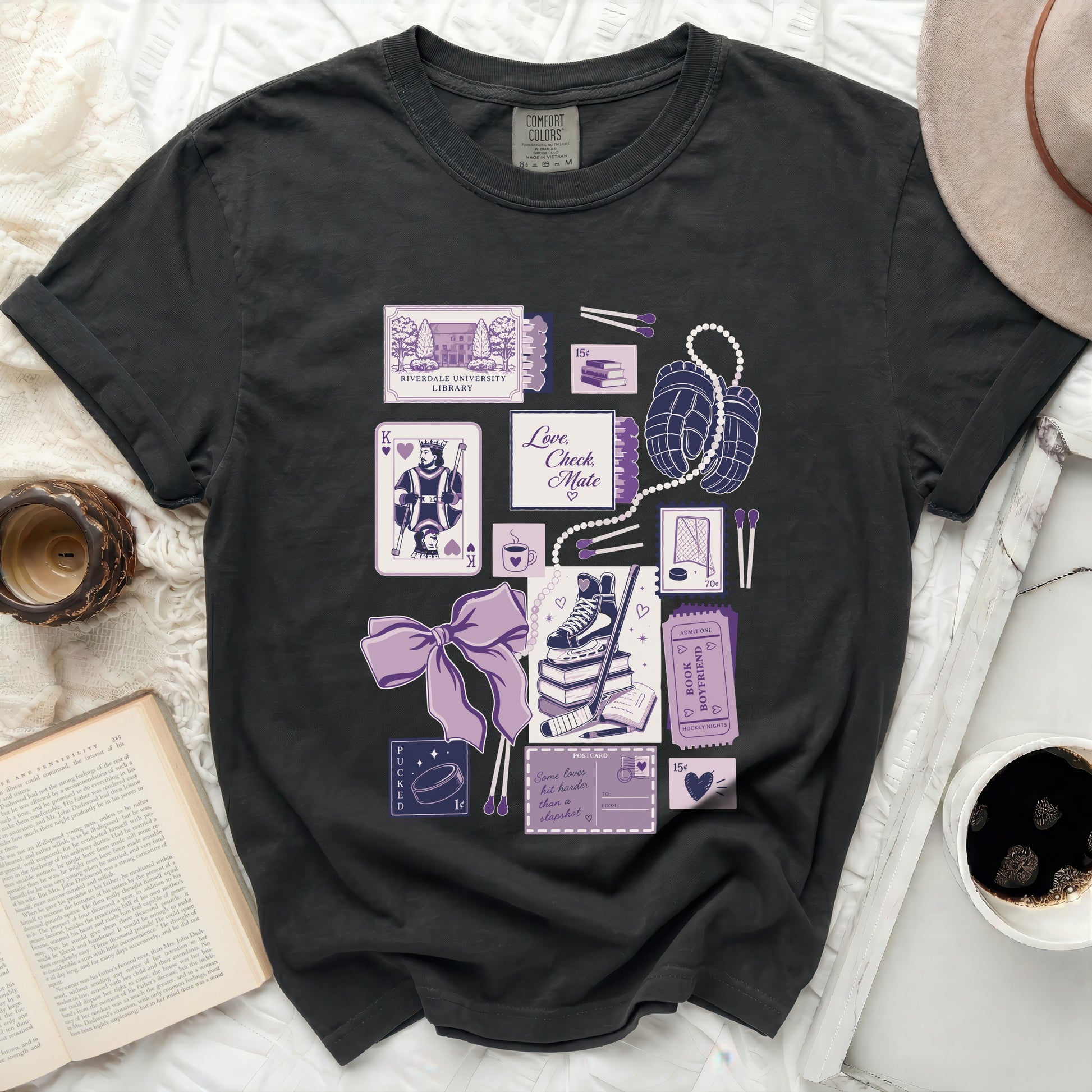 Dark t-shirt with purple graphic of playing cards, books, and hockey theme with text "Love Check Mate".