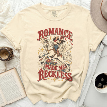 Cream t-shirt with "Romance Made Me Reckless" graphic of woman on winged horse.