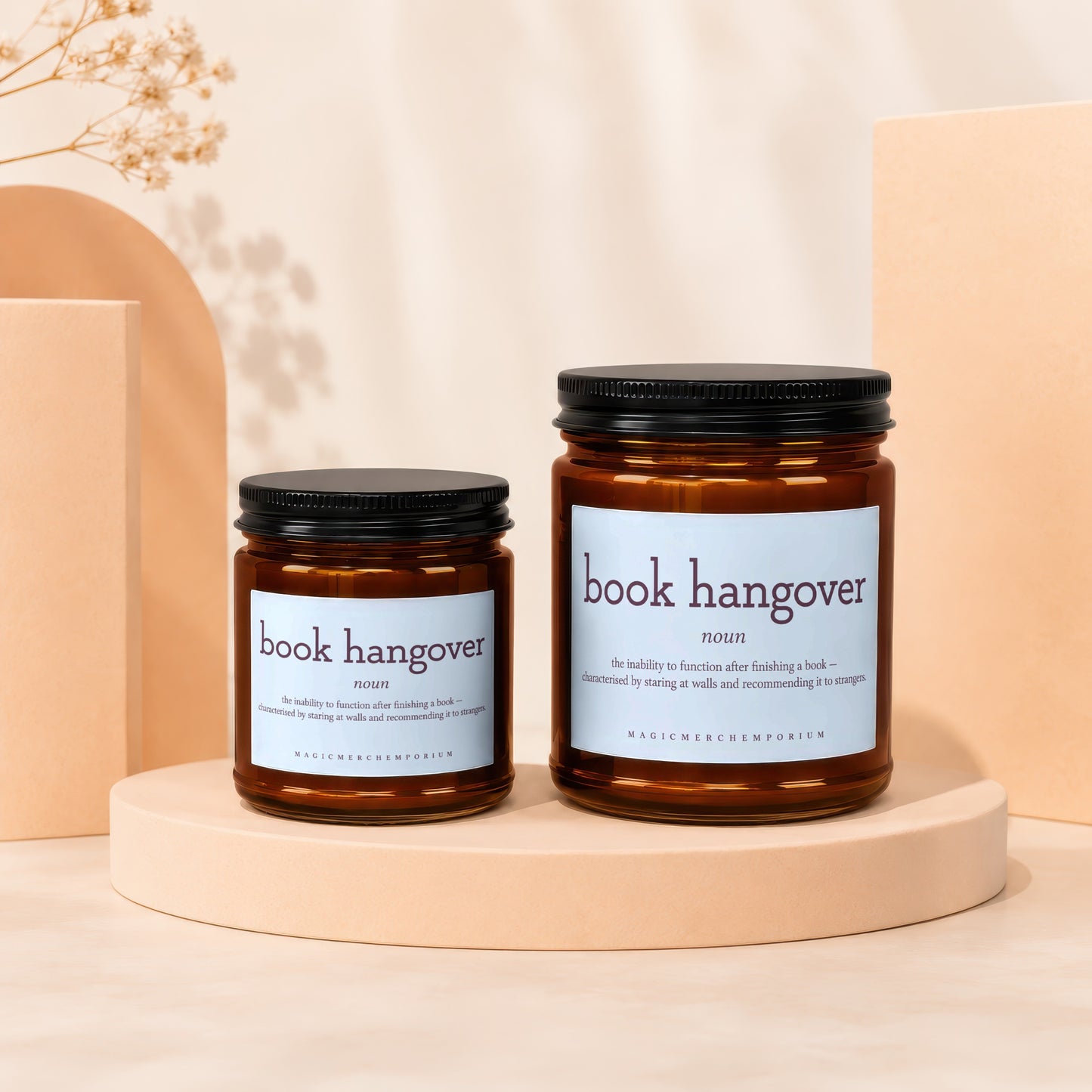 Two amber jar candles with "book hangover" printed on light blue labels.