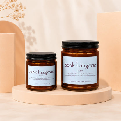 Two amber jar candles with "book hangover" printed on light blue labels.