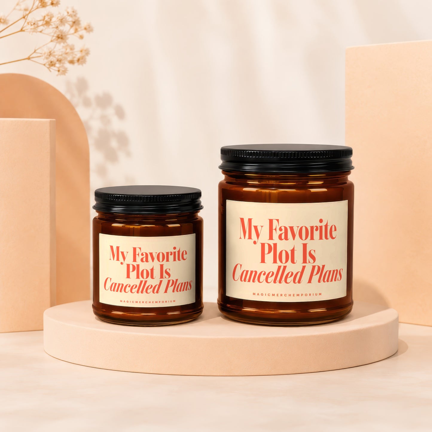 Two amber glass candles with cream labels saying "My Favorite Plot Is Cancelled Plans".