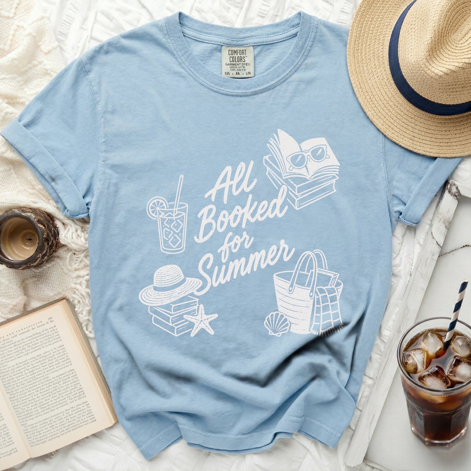 Light blue t-shirt with "All Booked for Summer" text and graphics.