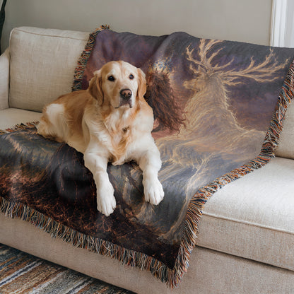 A golden retriever dog is lying on a couch, resting on a colorful blanket with a deer design.