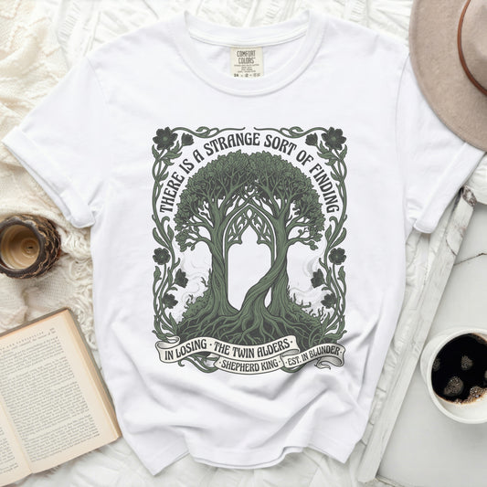 White t-shirt with a graphic design of two trees and text.