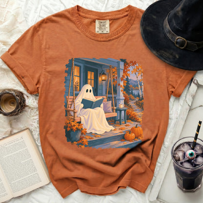 Ghost reading book on porch swing with pumpkins and fall leaves.