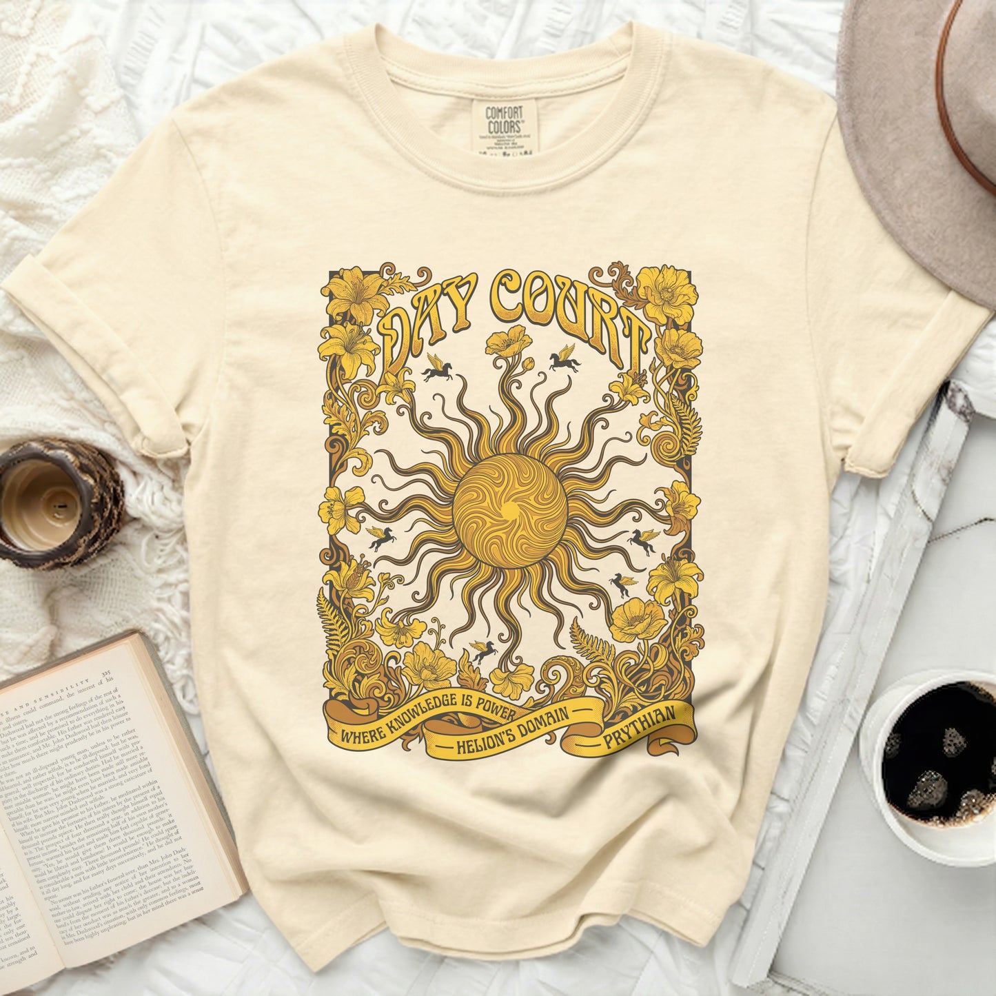 Cream t-shirt with yellow sun, floral border, and text.