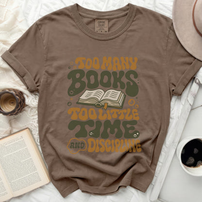 Brown t-shirt with "Too Many Books, Too Little Time and Discipline" graphic.