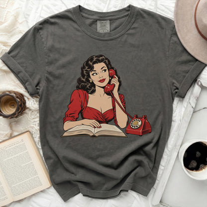 Graphic tee with a vintage comic-style woman talking on a red phone next to a book.