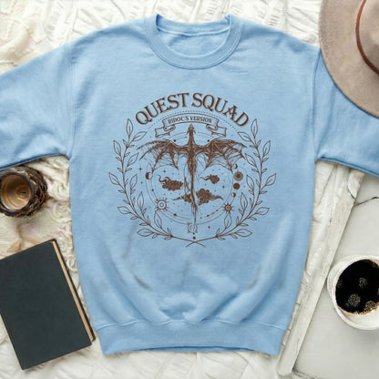 Light blue sweatshirt with brown "Quest Squad Ridoc's Version" dragon graphic.